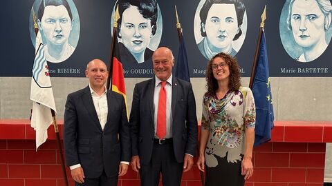 Europaminister Manfred Pentz mit dem Präsidenten der hessischen Partnerregion Nouvelle-Aquitaine sowie mit der Vizepräsidentin des Hessischen Landtages, Angela Dorn. Im Hintergrund sind Bilder mit historischen Persönlichkeiten zu sehen.