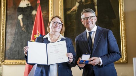 Ministerpräsident Boris Rhein mit Annette Ruske-Wolf bei der Auszeichnung. Ministerpräsident Boris Rhein überreicht Annette Ruske-Wolf das Verdienstkreuz am Bande.
