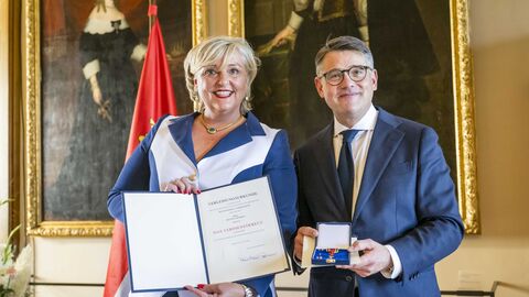 Ministerpräsident Boris Rhein mit Bettina Schmitt bei der Auszeichnung. Ministerpräsident Boris Rhein überreicht Bettina Schmitt das Verdienstkreuz am Bande.