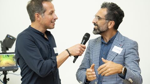  Willi Weitzel hält lächelnd Prof. Keywan Sohrabi ein Mikrofon hin