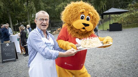 Die bekannte Buttercremetorte „Frankfurter Kranz“ erfreute sich großer Beliebtheit. Darüber freute sich ganz besonders der Vorsitzende des Vereins „Hessen in Berlin“, Bernd Gasser. Der Wahlberliner bot mit seinen Vereinsmitgliedern Kuchen an.  Das Maskottchen Hessen-Löwe und  der Vorsitzende des Vereins Hessen in Berlin halten eine große Torte Frankfurter Kranz in die Kamera