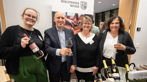 Europaminister Manfred Pentz steht zwischen 3 Frauen, die Wein verkaufen und ausschenken