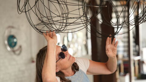 Eine Frau schaut sich ein Kunstwerk genauer an