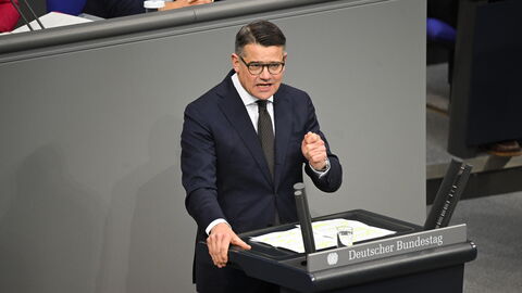 Ministerpräsident Rhein steht am Rednerpult des Bundestags und hält seine Rede.
