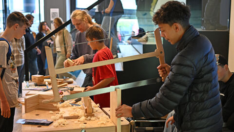 Ein Junge sägt Holz