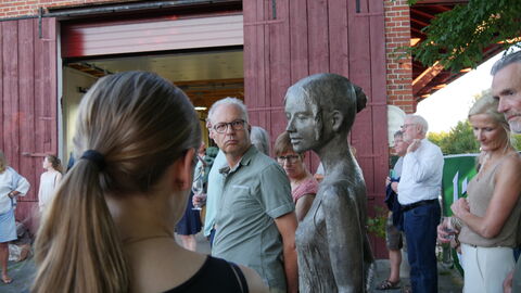 Kunst in Licher Scheunen Ein Mann betrachtet eine Skulptur