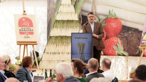Rede zur Eröffnung der Spargelsaison 2025 Ministerpräsident Rhein steht vor Publikum auf einer Bühne und hält eine Rede.