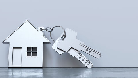 Ein silberner Schlüssel mit kleinem Häuschen-Anhänger