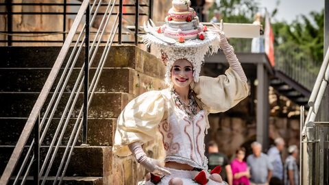Eine Artistin auf dem Hessentag in Bad Vilbel. Sie ist weiß gekleidet und trägt einen ausladenden Hut