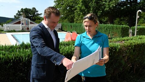 Der Chef der Hessischen Staatskanzlei, Staatssekretär Benedikt Kuhn, lässt sich das Waldschwimmbad Sinn zeigen.