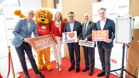 Lotto Hessen zu Gast in Berlin: Lotto-Chef Martin Blach, der Hessenlöwe, hr-Moderatorin und Lottofee Franziska Reichenbacher, Ministerpräsident Boris Rhein, Minister Manfred Pentz und Staatssekretär Benedict Kuhn (v.l.n.r.)