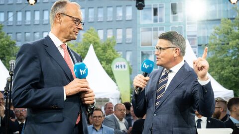 v.l.n.r.: Bundeskanzler Friedrich Merz und der Hessische Ministerpräsident Boris Rhein gemeinsam auf der Bühne