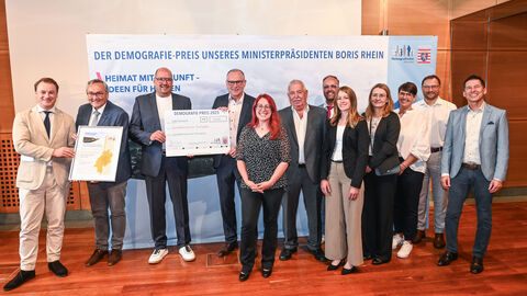 Gewinner Demografiepreis 2025 Eine Gruppe Menschen steht vor einer Wand