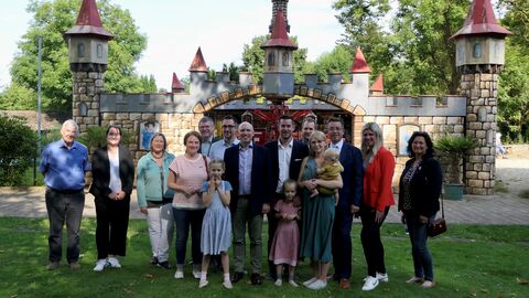 Besuch Erlebnispark Ziegenhagen Eine Gruppe um Minister Pentz steht auf einer Wiese im Erlebnispark zum Gruppenfoto aufgestellt.
