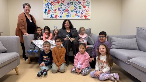 Europastaatssekretärin Karin Müller sitzt auf einer Couch mit den Kindern während des Vorlesetags.