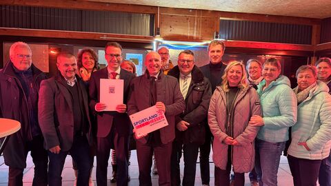 Staatsminister Manfred Pentz und weitere Beteiligte stehen zusammen bei der Bescheidübergabe in Fischbachtal. 
