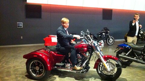 Mann sitzt auf einem Dreirad