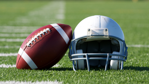 Football und Helm liegend auf Rasen