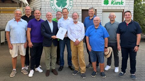 Herr Pentz steht mit 10 weiteren Männern vor einem Gebäude mit Aufschrift SV St. Stephan Griesheim 