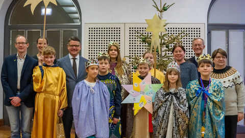 Eine Gruppe Sternsinger mit Ministerpräsident Rhein und Staatsminister Wintermeyer Eine Gruppe Sternsinger mit Ministerpräsident Rhein und Staatsminister Wintermeyer in der Staatskanzlei, sie halten Schilder in der Hand