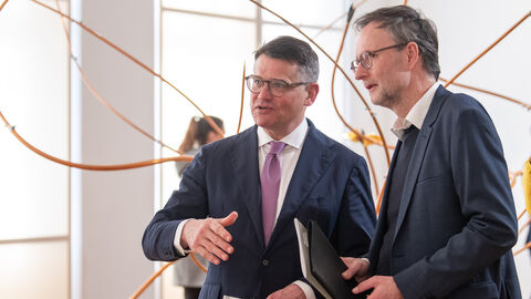 Ministerpräsident Rhein (links) steht neben Dr. Andreas Henning, dem Direktor des Museums Wiesbaden. Hinter ihnen eine der Kunstinstallationen der Künstlering Rebecca Horn.