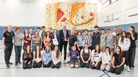 Kultusminister mit Schülerinnen und Schülern in Turnhalle