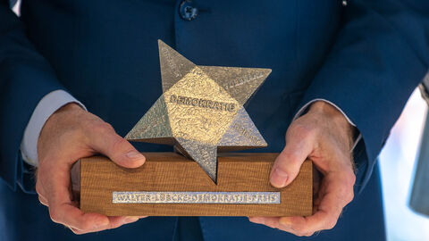 Nahaufnahme Walter-Lübcke-Demokratie-Preis Person hält Walter-Lübcke-Demokratie-Preis in den Händen