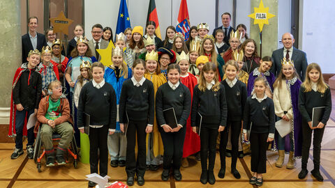 Viele Kinder stehen zusammen, teilweise als Könige verkleidet. 