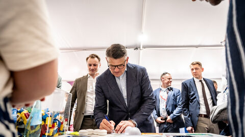 Ministerpräsident Boris Rhein unterschreibt ein Papier.