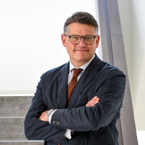 Boris Rhein Boris Rhein steht mit verschränkten Armen auf einer Treppe.